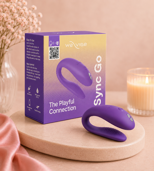 We-Vibe Sync Go wearable couples vibrator with purple packaging displayed on a soft beige luxury background
